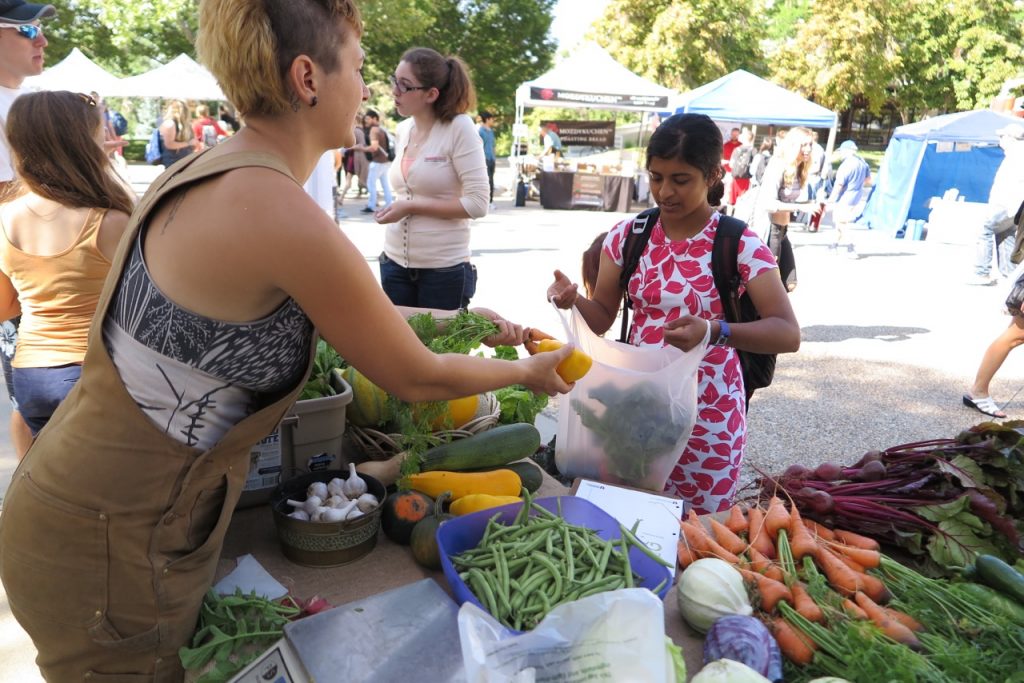 Edible Campus Garden Steward selling campus-grown, local produce at the University of Utah Farmers Market
