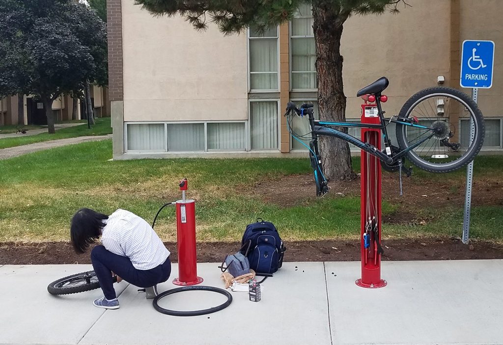 A student fixes their bike as the Fix-It Station installed in University Student Apartments using SCIF funds.